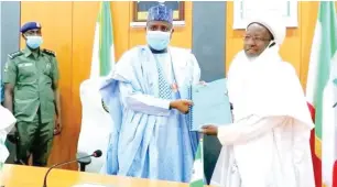  ??  ?? Chairman of the Committee to reorganise and harmonise the activities the hitherto Hisbah Commission in Sokoto State, Prof. Sambo Wali Junaidu, Waziri of Sokoto (right), presents the committee’s report to the state Governor, Aminu Waziri Tambuwal at Government House in Sokoto on Wednesday