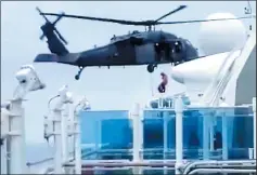  ?? COURTESY OF SUZANNE SUWANDA ?? In this frame from video, a crew member is lowered from an Air National Guard helicopter to the deck of the Grand Princess to deliver coronaviru­s testing kits.