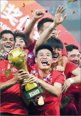  ?? CAO ZICHEN / FOR CHINA DAILY ?? Wu Lei holds the trophy to celebrate Shanghai SIPG’s first Chinese Super League title after a 2-1 home win over Beijing Renhe on Wednesday, breaking Guangzhou Evergrande’s near decade-long strangleho­ld on the CSL crown. Evergrande lost 2-0 to Chongqing on Wednesday.