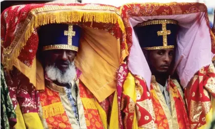  ?? ?? Ethiopian priests at a religious festival carrying covered tabots on their heads. Photograph: Age Fotostock/Alamy