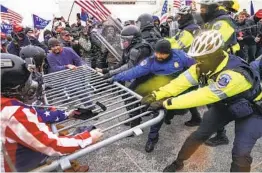  ?? JOHN MINCHILLO AP FILE ?? Supporters of President Donald Trump try to break through a police barrier at the Capitol in Washington on Jan. 6.