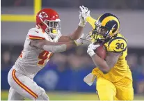  ?? KELVIN KUO/ASSOCIATED PRESS ?? Los Angeles running back Todd Gurley (30) fends off Kansas City’s Dorian O’Daniel during the Rams win Monday.