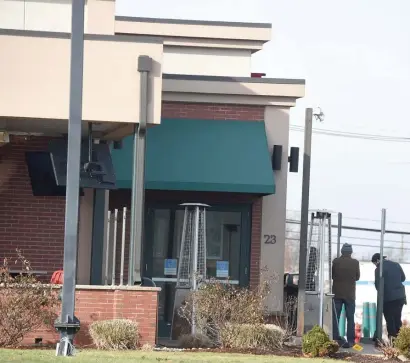  ?? JIM MICHAUD / BOSTON HERALD ?? THE DAY AFTER: Employees do a little cleaning outside of Jake n Joes restaurant, the location of a fatal shooting Saturday in Woburn.