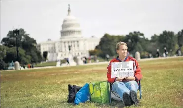  ?? Foto: Reuters ?? Sieht doch gar nicht so ungemütlic­h aus. Dennoch fordert der Beamte in Zwangsurla­ub vor dem Kapitol in Washington ein Ende des Government­Shutdown.