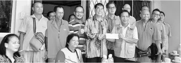  ??  ?? Ting (standing fourth left) presents government grant of RM5,000 to Remo.