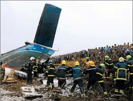  ?? NIRANJAN SHRESHTA/AP ?? Rescue workers search the crash site at the airport in Kathmandu on Monday.
