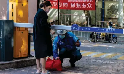  ?? ?? A woman in quarantine receives a food delivery in Shanghai: ‘For obvious reasons it is very hard to gauge public opinion.’ Photograph: Alex Plavevski/EPA