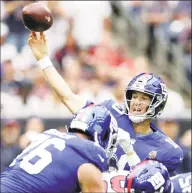  ?? Michael Wyke / Associated Press ?? Giants QB Eli Manning threw a pair of touchdown passes in Sunday’s win over the Texans in Houston.