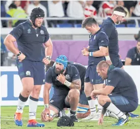  ??  ?? Scotland players react after losing to Japan at the World Cup.
