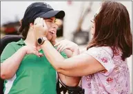  ?? Stephen M. Dowell / TNS ?? Isabelle Valle, left, a Special Olympics athlete who competes in “Golf Skills” events, gets some help donning a cap from her mom, Elaine Valle, at their home in Belle Isle on Friday.