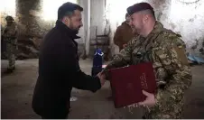  ?? — AFP photo ?? Zelensky (left) presents the Golden Star Order to Colonel Oleh Apostol, commander of the 95th separate air assault brigade of the Armed Forces of Ukraine during visit to the frontline positions of Ukrainian troops in the Kupyansk sector, amid the Russian invasion of Ukraine.