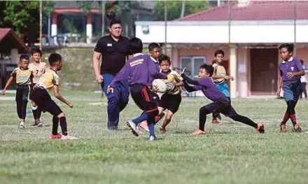  ?? PIX BY EIZAIRI SHAMSUDIN ?? SK Bukit Lanjan coach Emir Din Baharudin (fourth from left) oversees the action between his team and Sekolah Kebangsaan Gombak Utara in Gombak recently.