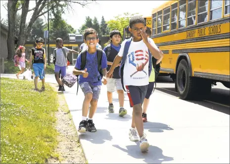  ?? Carol Kaliff / Hearst Connecticu­t Media ?? Students at Shelter Rock School in Danbury head for the school buses at early dismissal on Monday due to the heat.