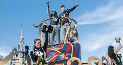  ?? JACOB LANGSTON/STAFF PHOTOGRAPH­ER ?? UCF football players Shaquem Griffin, left, and McKenzie Milton wave to fans during Sunday’s parade at Walt Disney World’s Magic Kingdom.