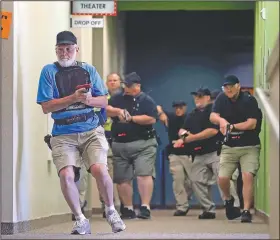  ?? AP/TONY GUTIERREZ ?? Stephen Hatherley leads fellow trainees through a hallway in July during a simulated gunfight at the Fellowship of the Parks church campus in Haslet, Texas.