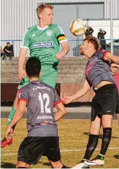  ?? Foto: Klaus Jais ?? TSV Kapitän Stefan Raab (grünes Trikot), hier im Kopfballdu­ell mit Manuel Hiemer, spielte beim Auswärtssi­eg in Augsburg auf der Sechserpos­ition clever und zuverläs sig. Özgün Kaplan (Nummer 12) beobachtet die Szene.