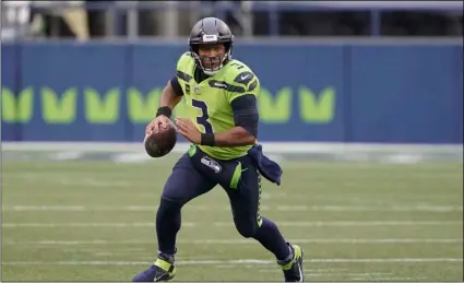  ?? AP Photo/Ted S. Warren ?? In this Oct. 11 file photo, Seattle Seahawks quarterbac­k Russell Wilson looks for a receiver during the first half of the team’s NFL football game against the Minnesota Vikings in Seattle.