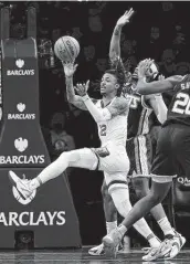  ?? Elsa / Getty Images ?? The Grizzlies’ Ja Morant, left, passes as the Nets’ Bruce Brown tries to defend. Morant finished with 36 points, including 18 in the third quarter.