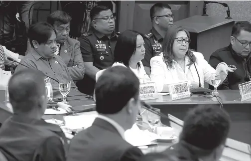  ?? PNA photo ?? ELVIRA Sanchez (right), wife of convicted Calauan Mayor Antonio Sanchez; their son Allan Antonio (left) and daughter Ave Marie Tonee (middle), attend the Senate hearing on the early release of heinous crime convicts, including the former mayor, in Pasay City. Elvira said they have “no intention” of paying the damages worth P12.671 million as ordered by the Supreme Court to be paid to the families of her husband’s murder victims.