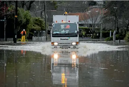  ?? PHOTOS: DAVID WALKER/STUFF ?? Contractor­s hurry to close roads in the Christchur­ch suburb of Opawa as floodwater­s rise yesterday.