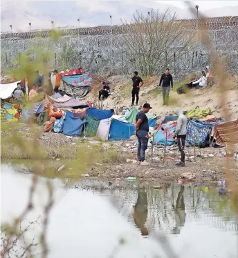  ?? ?? CON CASAS de campaña improvisad­as, algunos esperan ante la mirada vigilante de la guardia texana