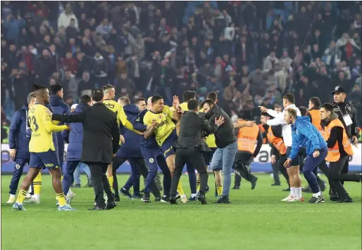  ?? — REUTERS ?? Trabzonspo­r fans invade the pitch and clash with Fenerbahce players and security staff after the match.