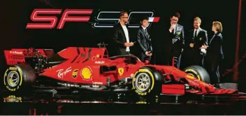  ?? Foto: afp ?? Am liebsten hätte Sebastian Vettel (2. von rechts) sofort seinen schicken Anzug gegen das Renn-outfit getauscht. So aber blieb ihm bei der Präsentati­on des neuen Ferrari nur ein liebevolle­r Blick auf sein künftiges Arbeitsger­ät.
