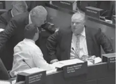  ?? CHRIS SO/TORONTO STAR ?? Councillor­s Giorgio Mammoliti and Doug Ford speak to Mayor Rob Ford during Thursday’s council session on the ombudsman’s report.