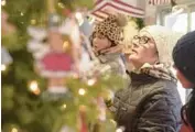  ?? MARK BLACK/BEACON-NEWS ?? Diana Grasser, of Peru, Ill., browses for the perfect item while visiting the Christkind­lmarket in Aurora with her daughters on Nov. 18.