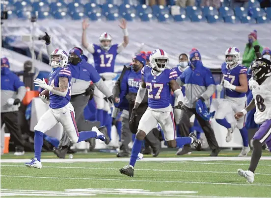  ?? AP ?? Cornerback Taron Johnson sprints away from Ravens QB Lamar Jackson (8) on his way to the end zone during an intercepti­on return that matched the longest in NFL history.