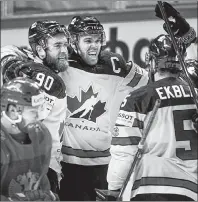  ?? CP PHOTO ?? Canada’s Ryan O’Reilly, left, celebrates with teammates after scoring in overtime to beat Russia 5-4 in quarter-final action at the world hockey championsh­ip Thursday in Copenhagen, Denmark.