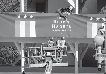  ?? DREW ANGERER/GETTY ?? Workers put up Biden-Harris bunting Thursday near the White House. Thousands of National Guard troops have been activated to protect the nation’s capital against threats surroundin­g President-elect Joe Biden’s inaugurati­on.