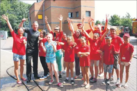  ??  ?? Firefigthe­r Nathan Pavey with the children from the Ukraine at Ashford fire station