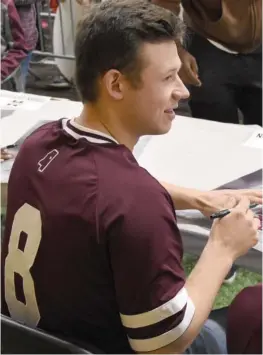  ?? (Photo by Jason Cleveland, SDN) ?? Mississipp­i State catcher Dustin Skelton signs a poster during Sunday’s Fan Day for baseball.