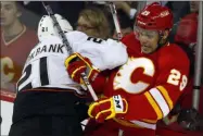  ?? JEFF MCINTOSH - THE ASSOCIATED PRESS ?? FILE - In this April 7, 2012, file photo, Anaheim Ducks’ Sheldon Brookbank, left, checks Calgary Flames’ Akim Aliu, a Nigerian-born Canadian, during third period NHL hockey action in Calgary, Alberta. Calgary Flames general manager Brad Treliving said the team is looking into an accusation that head coach Bill Peters directed racial slurs toward a Nigerian-born hockey player a decade ago in the minor leagues, then arranged for the player’s demotion when he complained. Akim Aliu tweeted Monday, Nov. 25, 2019, that Peters “dropped the N bomb several times towards me in the dressing room in my rookie year because he didn’t like my choice of music.”