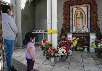  ?? Photos by Richard Vogel / Associated Press ?? Parishione­rs pray at a damaged Virgin of Guadalupe mural at St. Elisabeth Catholic Church in Los Angeles’ Van Nuys section.