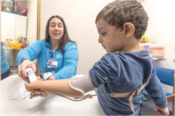  ?? ?? Four-year-old Omar Abu Kuwaik learns to use his new prosthetic arm Wednesday with occupation­al therapist Meghan Gossenberg­er at Shriners Children’s Hospital in Philadelph­ia. (AP photo/peter K. Afriyie)