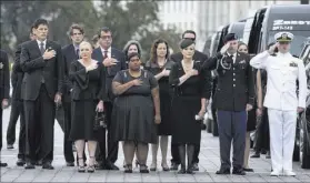  ??  ?? The family of Sen. John McCain watches as his casket is carried from the steps of the U.S. Capitol on Saturday to a memorial service at the National Cathedral.