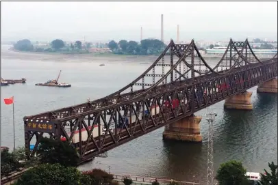  ?? The Associated Press ?? MAXIMUM PRESSURE: In this Sept. 4, 2017, file photo, trucks cross the Friendship Bridge connecting China and North Korea in the Chinese border town of Dandong, opposite the North Korean town of Sinuiju. As the U.S.-North Korea summit looms, President...