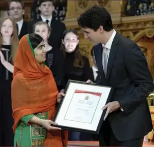  ?? ADRIAN WYLD/THE CANADIAN PRESS ?? Nobel Peace Prize winner Malala Yousafzai is presented with an honorary Canadian citizenshi­p Wednesday by Prime Minister Justin Trudeau.