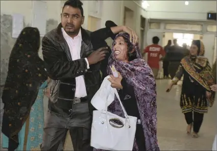  ?? PICTURE: AP ?? A man helps a woman who was injured in the suicide attack on a church in Quetta, Pakistan, yesterday. Two suicide bombers attacked the church when hundreds of worshipper­s were attending services before Christmas.