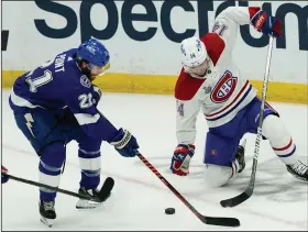  ?? (AP/Gerry Broome) ?? Tampa Bay Lightning center Brayden Point (left) and Montreal Canadiens center Nick Suzuki play the puck during the second period of Game 1 of the Stanley Cup Final Monday night in Tampa, Fla. The Lightning lead the best-of-seven series 1-0 with Game 2 tonight.