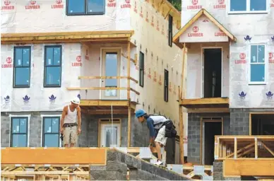  ?? STAFF FILE PHOTO BY DOUG STRICKLAND ?? Workers construct townhomes in the Cameron Harbor developmen­t on Riverfront Parkway in downtown Chattanoog­a.