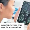  ?? ?? A doctor checks a brain scan for abnormalit­ies