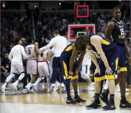  ?? TONY AVELAR — THE ASSOCIATED PRESS ?? West Virginia players react as Gonzaga celebrates its victory in the West Regional semifinal on Thursday in San Jose, Calif.