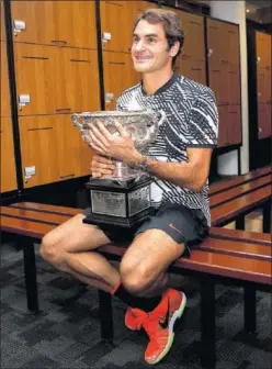  ??  ?? YA TIENE CINCO. Federer abraza el trofeo en los vestuarios.