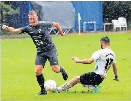  ?? RP-FOTO: ARMIN FISCHER ?? Norwin Meyer, der sich hier nicht von Repelens Yusuf Kuci stoppen lässt, gewann das verregnete Heimspiel mit dem TuS Xanten mit 3:1.