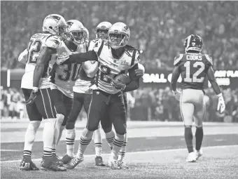  ?? MARK J. REBILAS/USA TODAY SPORTS ?? New England cornerback Stephon Gilmore (24) celebrates with teammates after intercepti­ng Jared Goff in the fourth quarter.