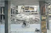  ?? AFP ?? A man rides past destroyed buildings in the rebelheld town of Douma, on the eastern outskirts of Damascus, on Saturday.