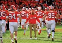  ?? STREETER LECKA / GETTY IMAGES ?? Coach Dabo Swinney and his Tigers loosen up before their game against Wake Forest last month. The Demon Deacons were ranked No. 19 a month ago and have since lost three of four. They were beaten 52-3 by Clemson.